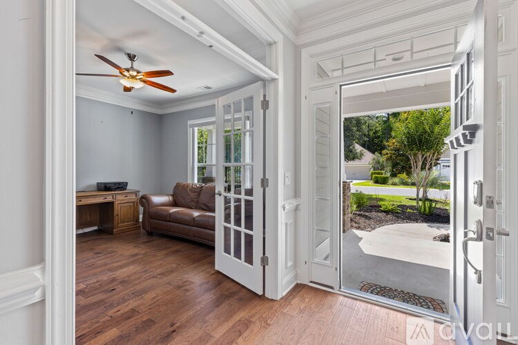 A room with a ceiling fan and a brown couch.