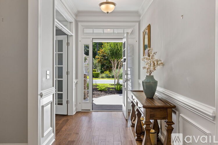 A hallway with a wooden bench and a vase on it.