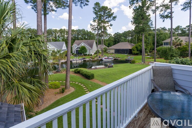 A house with a white fence and a patio table.