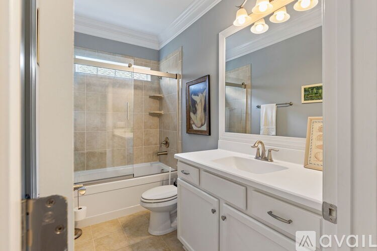 A bathroom with a toilet, sink, and mirror.