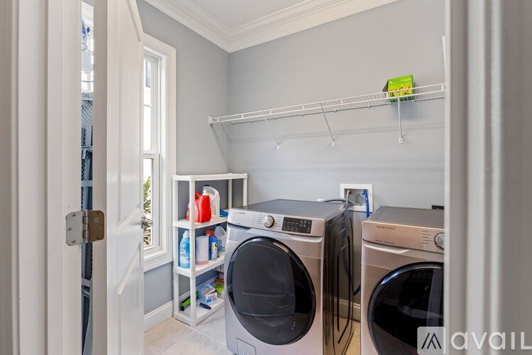 A laundry room with two washing machines and a shelf with cleaning supplies.