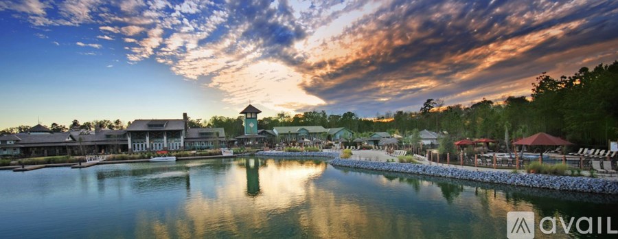 A serene waterfront scene with a building in the background and a clear sky.
