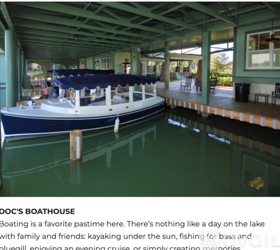 A blue boat is docked at a boathouse.