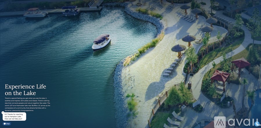 A boat is floating on a lake next to a sandy beach.