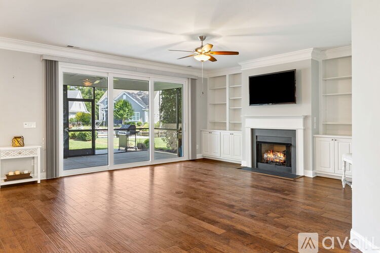 A living room with a fireplace and a flat screen TV mounted above it.