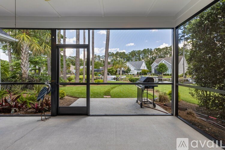 A patio with a table and chairs is shown through a glass door.