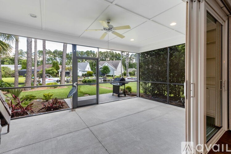 A patio with a ceiling fan and sliding glass doors.