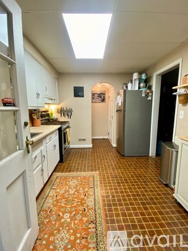 A kitchen with a tile floor and a skylight.