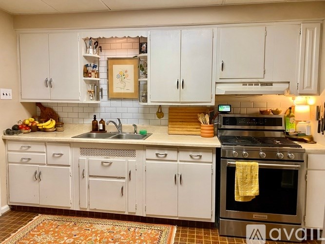 A kitchen with white cabinets and a tile backsplash.
