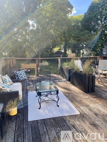 A wooden deck with a glass table and chairs.