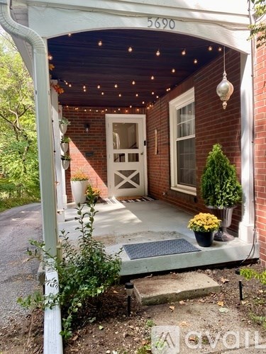 A house numbered 5690 has a porch with lights and a door.