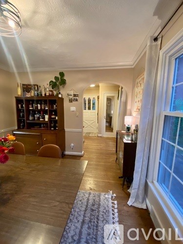 A living room with a wooden floor and a bar area.