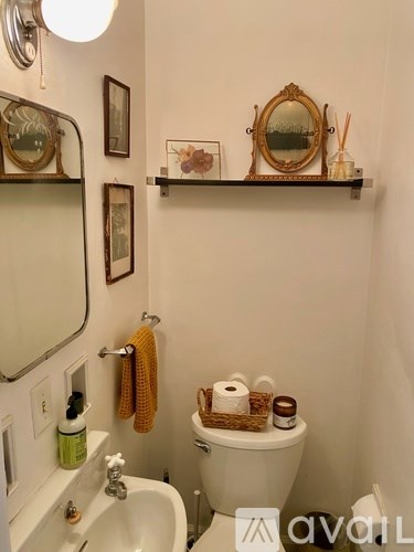 A white toilet with a basket on top of it.
