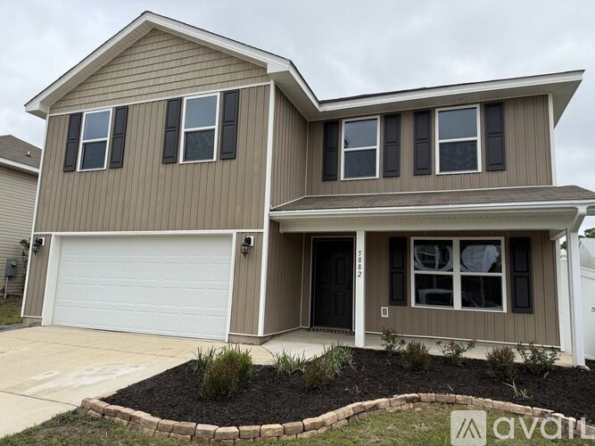 A two-story house with a garage and a driveway.