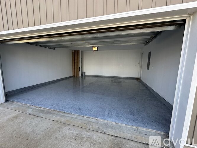 A spacious garage with a concrete floor and a closed door.