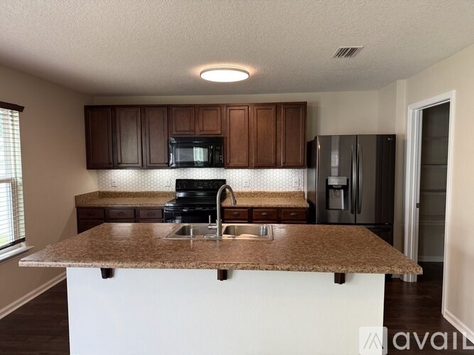 A kitchen with brown cabinets and a granite countertop.
