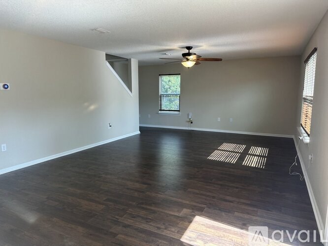 A room with wooden flooring and a ceiling fan.