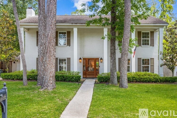 A white house with a brown door and a flag on the window.