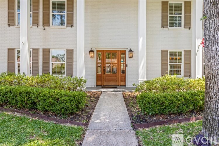 A white building with a brown door and windows.