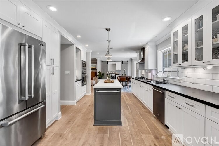 A modern kitchen with stainless steel appliances and white cabinetry.