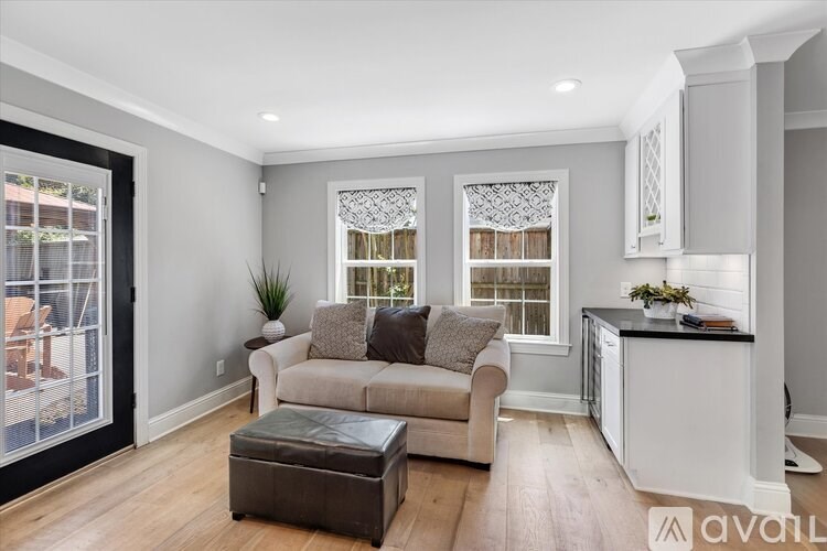 A living room with a couch, a table, and a window with curtains.