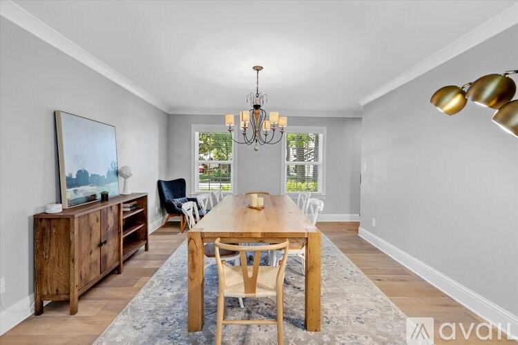 A dining room with a wooden table and chairs.
