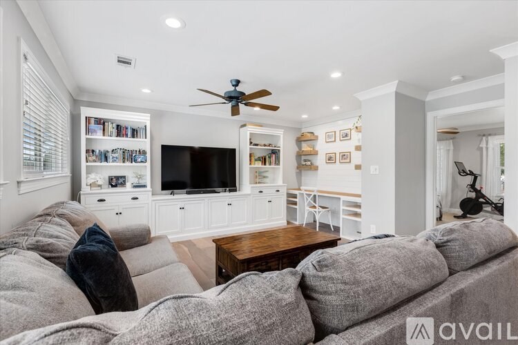 A living room with a grey couch and a television.