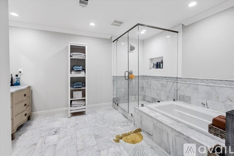 A bathroom with a marble floor and a walk-in shower.