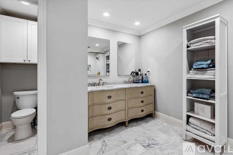 A bathroom with a marble floor and a white toilet.