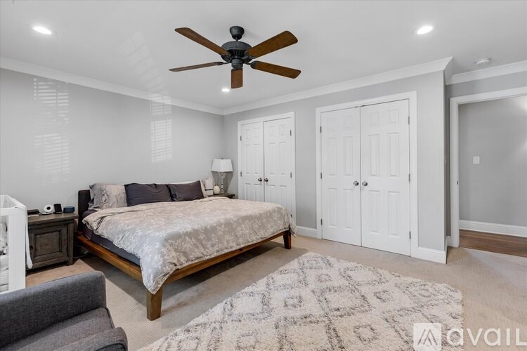 A bedroom with a bed, a ceiling fan, and a rug.