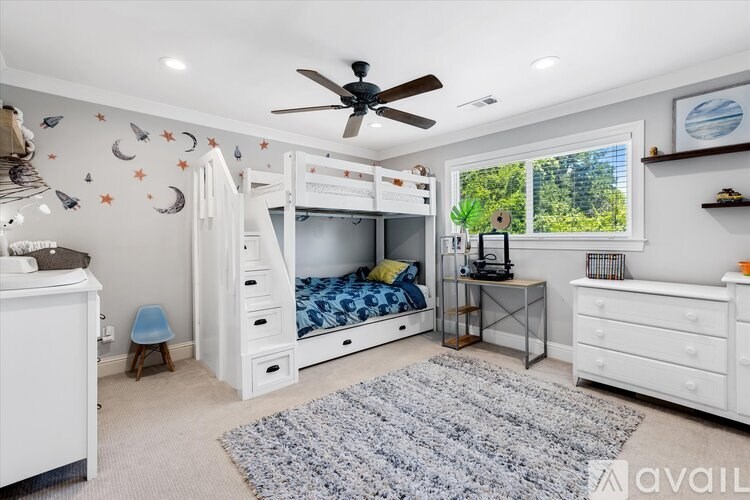 A bedroom with a bunk bed and a desk.