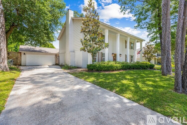 A white house with a driveway in front.