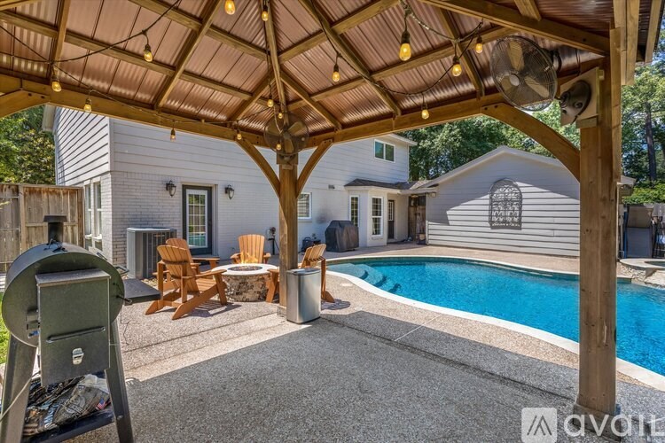 A covered patio area with a pool and a grill.