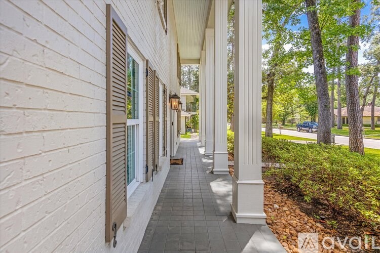 A white house with a porch and pillars.