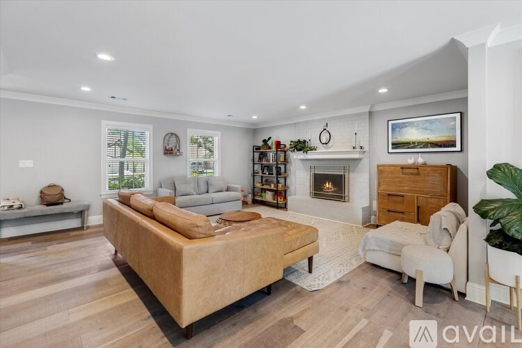A living room with a couch, a coffee table, a fireplace, and a painting on the wall.