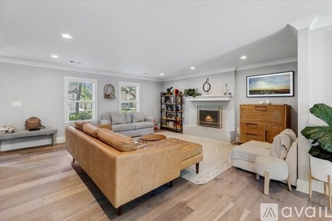A living room with a couch, a coffee table, a fireplace, and a painting on the wall.