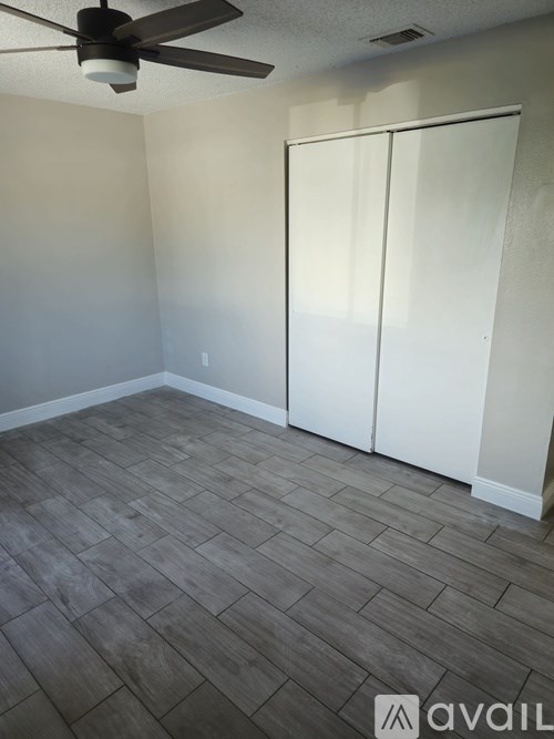 A room with a ceiling fan and a sliding door.