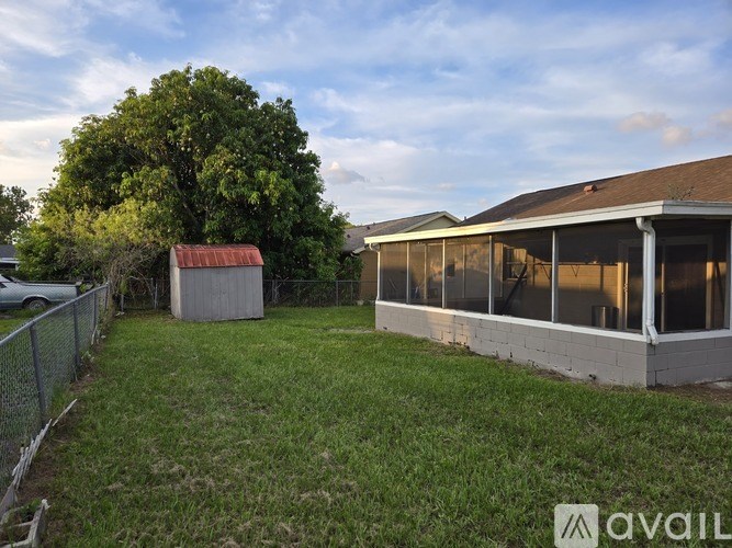 A backyard with a shed and a fence.