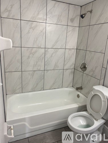 A white toilet is next to a bathtub in a bathroom.