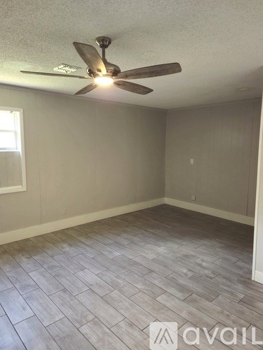A room with a ceiling fan and a window.