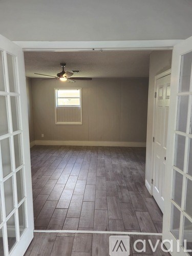 A room with a ceiling fan and a window.