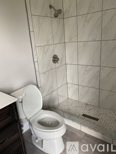 A white toilet in a bathroom with marble tiles.