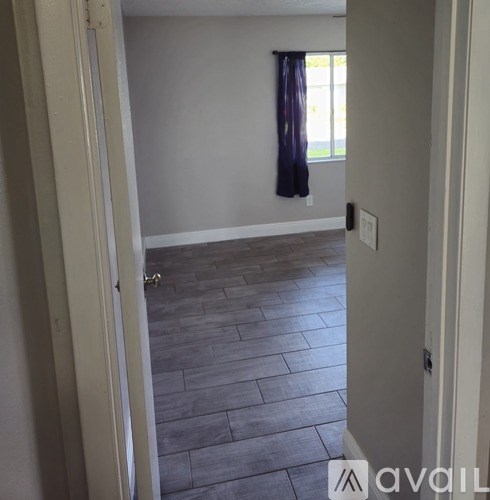 A room with a window and a curtain.