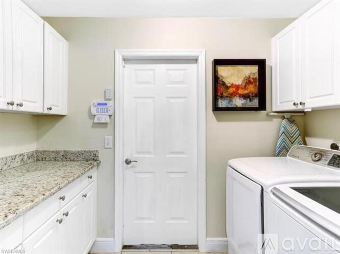 A white door is in the middle of a kitchen with a counter and a washing machine.