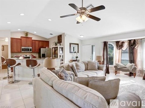 A living room with a white couch and a ceiling fan.