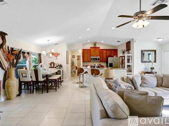 A spacious living room with a white couch and a dining table with chairs.