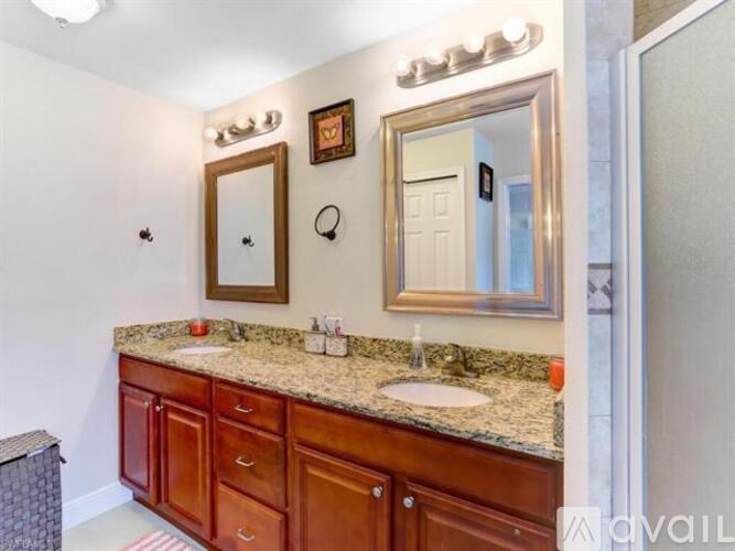 A bathroom with a granite countertop and a large mirror above it.