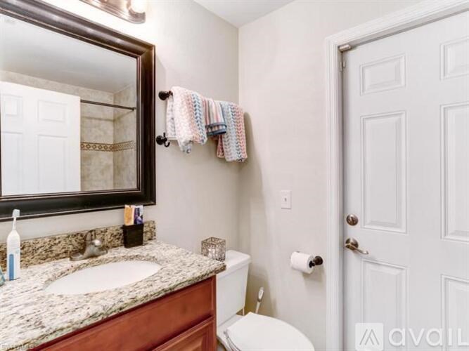 A bathroom with a sink, toilet, and a mirror.