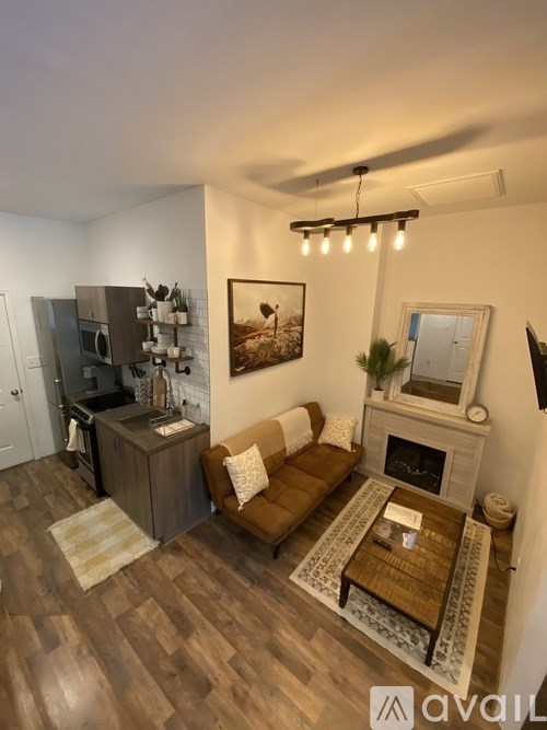 A living room with a brown couch, a coffee table, and a fireplace.