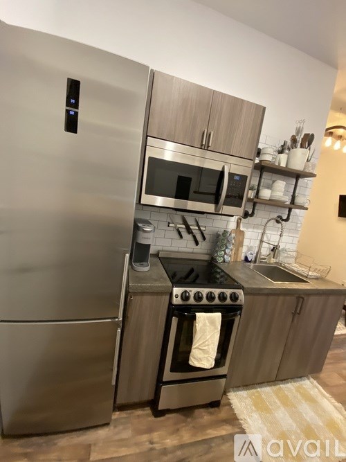 A modern kitchen with a stainless steel refrigerator and a stove top oven.